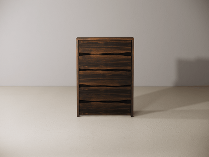 Wooden dresser with five drawers against a plain wall. 